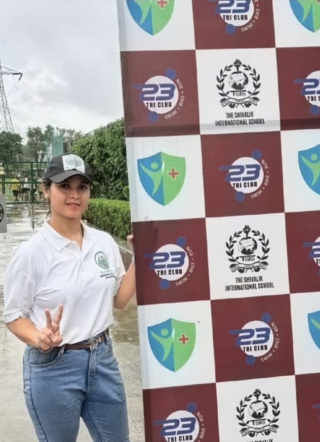 Founder beside the 23 Tri Club event backdrop before the race