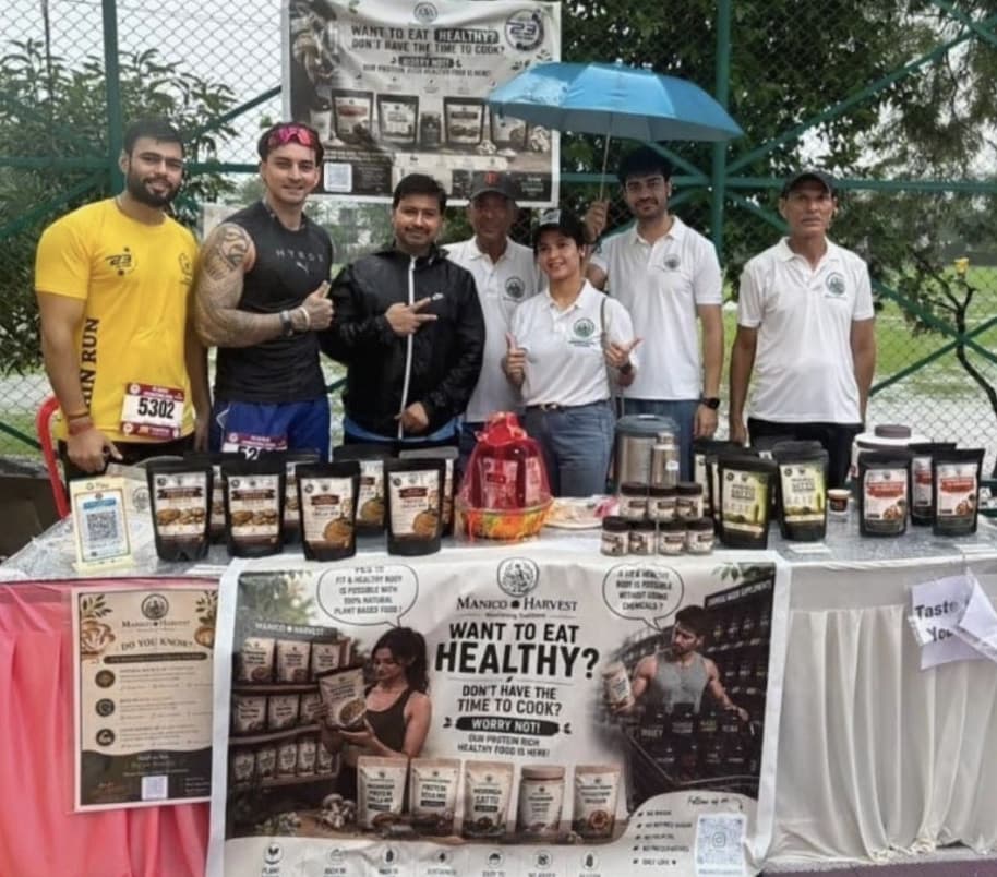 The Manico Harvest team with runners and athletes gathered around the stall